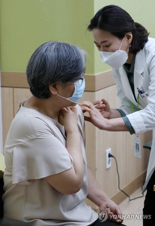 Jeong Eun-kyeong (L), head of the Korea Disease Control and Prevention Agency (KDCA), is given an AstraZeneca vaccine at an injection center in Cheongju, 150 kilometers south of Seoul, on April 1, 2021. (Yonhap)