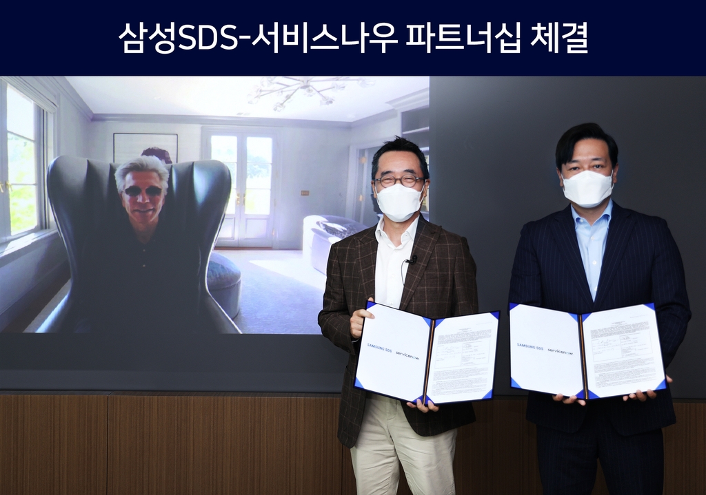 This photo provided by Samsung SDS Co. on June 29, 2021, shows the company's CEO Hwang Sung-woo (C) posing for a photo with ServiceNow CEO Bill McDermott (L) and ServiceNow Korea chief Kim Gyu-ha (R) after signing a partnership at the company's office in Seoul. (PHOTO NOT FOR SALE) (Yonhap)