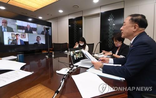 This file photo, provided by the Ministry of Economy and Finance on July 6, 2021, shows South Korean Finance Minister Hong Nam-ki (R) holding an online meeting with officials from global rating agency Fitch Ratings. (PHOTO NOT FOR SALE) (Yonhap)