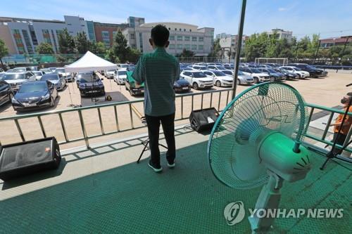 A pastor preaches a sermon during a drive-in church service on high school grounds in northeastern Seoul on July 25, 2021. (Yonhap)