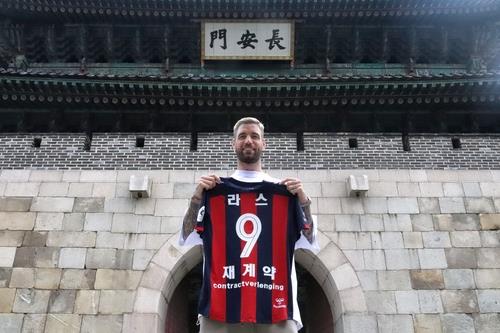Lars Veldwijk of Suwon FC poses with his uniform with the words "re-signed" at the bottom after agreeing to a one-year extension with the K League 1 club on Aug. 30, 2021, in this photo provided by Suwon FC. (PHOTO NOT FOR SALE) (Yonhap)