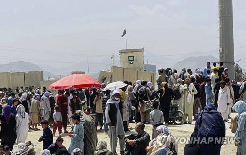 This file photo, released by the Associated Press on Aug. 17, 2021, shows people gathering outside the international airport in Kabul, Afghanistan. (Yonhap)
