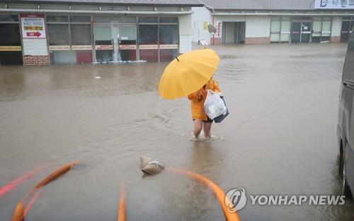 A resident walks on a flooded road in Jeju, South Korea, on Sept. 17, 2021. (Yonhap)
