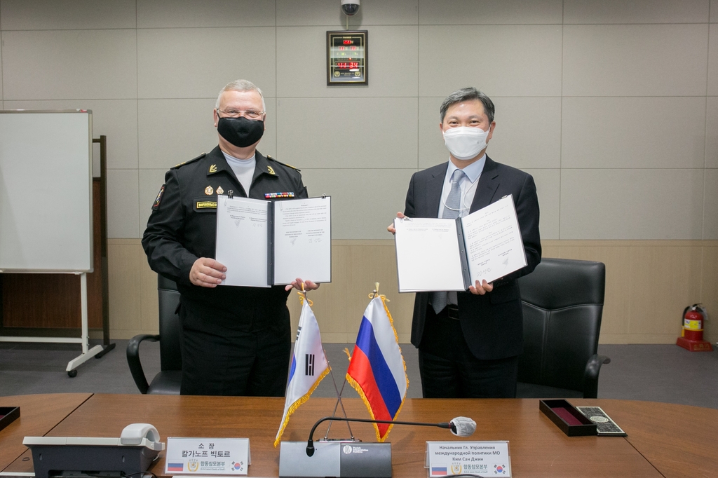 Kim Sang-jin (R), the defense ministry's director general for international policy, and Viktor Kalganov, deputy director of Russia's National Defense Control Center, pose for a photo in Seoul after signing a memorandum of understanding to establish military hotlines between the two countries on Nov. 11, 2021, in this photo released by the ministry. (PHOTO NOT FOR SALE) (Yonhap)