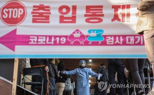 A medical worker guides people waiting to receive coronavirus tests at a screening clinic in Seoul's Songpa Ward on Nov. 14, 2021. (Yonhap)