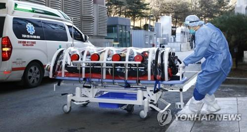This undated photo, provided by NHIS Ilsan Hospital, shows a hospital worker moving a COVID-19 patient in Ilsan, a suburb of Seoul. (PHOTO NOT FOR SALE) (Yonhap) 