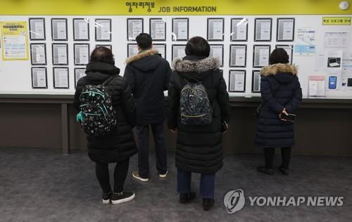 This undated file photo shows job seekers looking at employment information at a job arrangement facility in Seoul. (Yonhap)