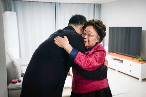 First Vice Foreign Minister Choi Jong-kun (L) hugs Lee Yong-soo, a survivor of wartime sexual slavery, during his visit to Lee's house in the southeastern city of Daegu, in this photo provided by the foreign ministry on Nov. 30, 2021. (PHOTO NOT FOR SALE) (Yonhap)