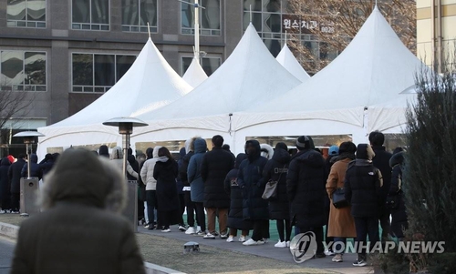 People wait in line to get COVID-19 tests at a makeshift virus testing clinic in Seoul on Dec. 26, 2021. (Yonhap)