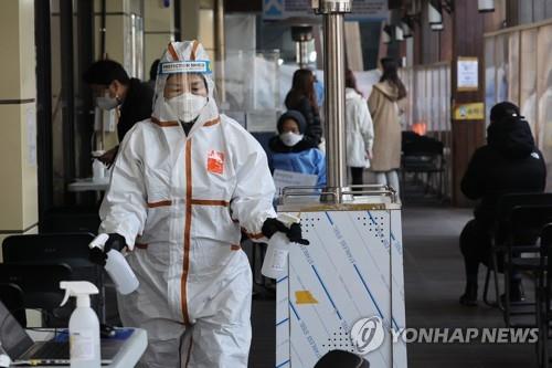 A health worker sprays disinfectant at a COVID-19 testing station in Seoul on Jan. 10, 2022. (Yonhap)