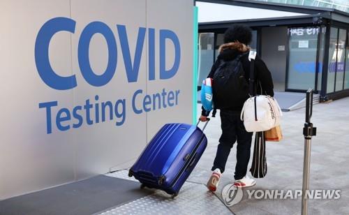 A person moves to a COVID-19 testing station set up at Incheon International Airport, west of Seoul, upon arrival in South Korea on Jan. 13, 2022. (Yonhap)