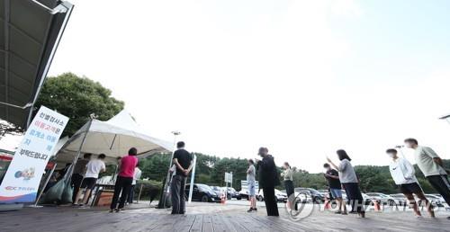 This file photo, taken Sept. 22, 2021, shows people waiting to receive a COVID-19 test at a temporary testing station set up at a highway rest area in Yongin, 49 kilometers south of Seoul. (Yonhap)