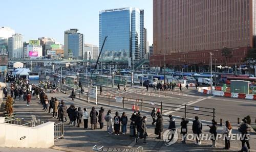People wait in line to receive COVID-19 tests at a makeshift testing station in Seoul on Feb. 21, 2022. (Yonhap)