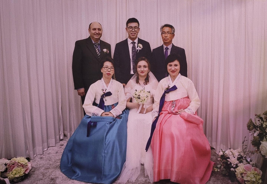 This file photo provided by Alina Shymanska (bottom row, C), a Ukrainian Ph. D. candidate-researcher at South Korea's Seoul National University, shows a photo of her Ukrainian parents, and South Korean husband and in-laws, at her wedding held in Seongnam, south of Seoul, in 2016. (PHOTO NOT FOR SALE) (Yonhap)