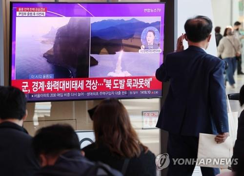 People at Seoul Station watch a television news report on North Korea's missile provocations on Nov. 2, 2022. (Yonhap)