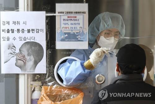 A health worker conducts a coronavirus test at a testing center at Seoul Station on March 8, 2022. (Yonhap)