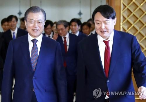 President Moon Jae-in (L) walks with new Prosecutor General Yoon Suk-yeol at Cheong Wa Dae in Seoul on July 25, 2019, after presenting him with a letter of appointment. (Yonhap)
