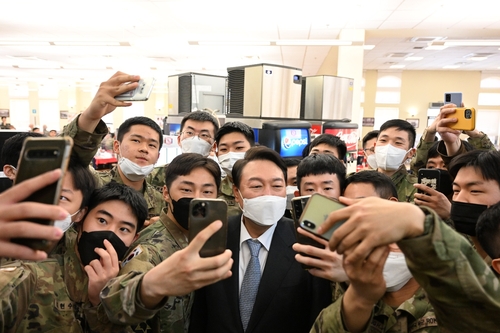 President-elect Yoon Suk-yeol (C) takes selfies with troops at Camp Humphreys in Pyeongtaek, 70 kilometers south of Seoul, on April 7, 2022, in this photo provided by his office. (Yonhap)