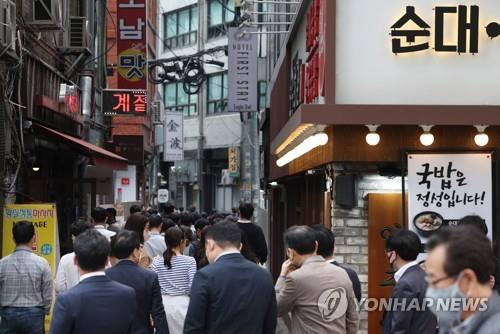 Office workers go to have lunch in Seoul on April 12, 2022. (Yonhap)