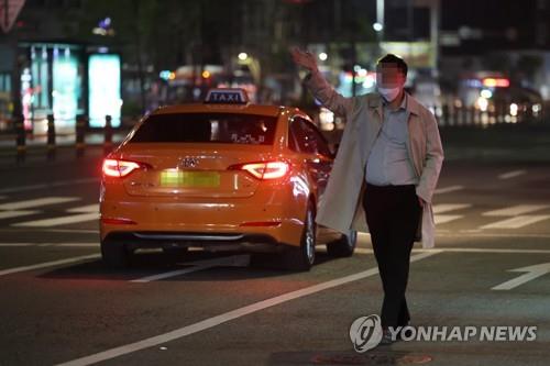 A people tries to flag down a taxi in the busy district of Gangnam in southern Seoul on April 19, 2022. (Yonhap)