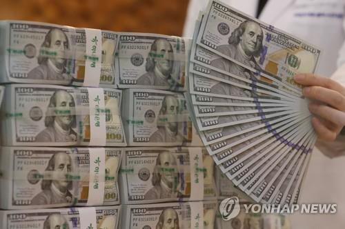 An official sorts US$100 banknotes at the headquarters of Hana Bank in Seoul, in this file photo taken May 12, 2022. (Yonhap)
