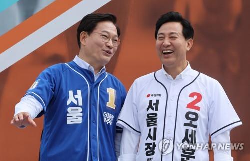 This file photo taken May 21, 2022, shows Seoul mayoral election candidates Oh Se-hoon (R) of the ruling People Power Party and Song Young-gil of the main opposition Democratic Party at a marathon event in Seoul. (Yonhap)