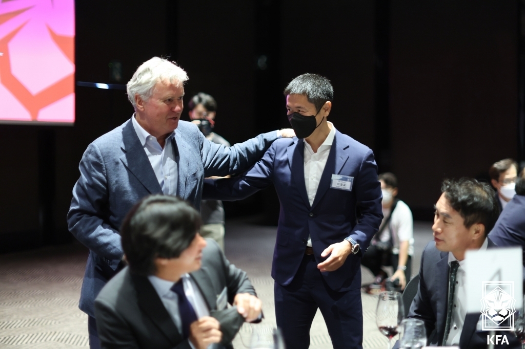 Guus Hiddink (L), head coach of South Korea at the 2002 FIFA World Cup, greets his former player Lee Young-pyo during a luncheon in Seoul celebrating the 20th anniversary of the World Cup on June 2, 2022, in this photo provided by the Korea Football Association. (PHOTO NOT FOR SALE) (Yonhap)