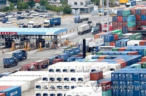 Trucks transport containers at a pier in Busan on June 6, 2022, a day before unionized cargo truckers were set to go on a general strike. (Yonhap) 
