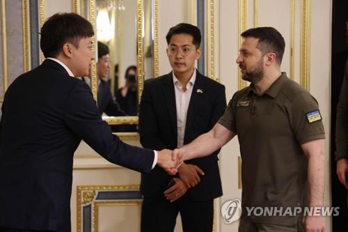 Ruling People Power Party (PPP) Chairman Lee Jun-seok (L) shakes hands with Ukrainian President Volodymyr Zelenskyy at an undisclosed location in Ukraine on June 6, 2022, in this photo provided by the PPP. (PHOTO NOT FOR SALE) (Yonhap)
