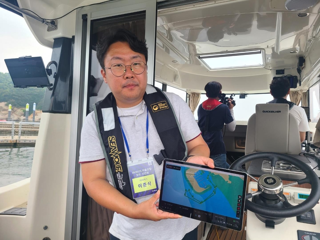 This photo taken on July 12, 2022, shows an Avikus official holding the company's autonomous navigation assist system during a media event in Incheon, just west of Seoul. (Yonhap)