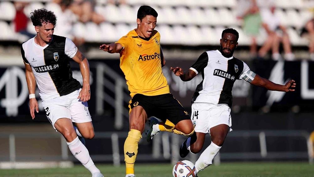 Hwang Hee-chan of Wolverhampton Wanderers (C) battles Fabricio Isidoro of SC Farense for the ball during the clubs' preseason friendly match at Estadio Algarve in Algarve, Portugal, on July 31, 2022, in this photo provided by Wolverhampton. (PHOTO NOT FOR SALE) (Yonhap)