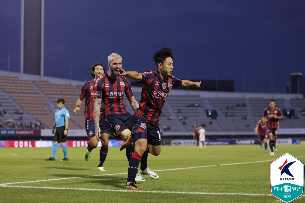 In this July 16, 2022, file photo provided by the Korea Professional Football League, Lee Seung-woo of Suwon FC (R) celebrates his goal against Gangwon FC during the clubs' K League 1 match at Suwon Stadium in Suwon, 35 kilometers south of Seoul. (PHOTO NOT FOR SALE) (Yonhap)