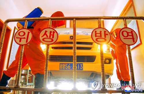 Workers disinfect a vehicle at a post office in Pyongyang amid the coronavirus pandemic, in this undated file photo released by the North's official Korean Central News Agency on May 23, 2022. (For Use Only in the Republic of Korea. No Redistribution) (Yonhap)