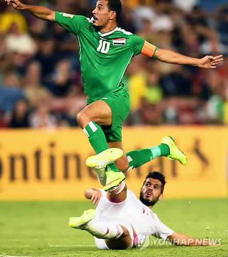 In this EPA file photo from Jan. 30, 2015, Younis Mahmoud of Iraq (in green) jumps over Majed Hassan of the United Arab Emirates during the teams' third place match at the Asian Football Confederation Asian Cup at Hunter Stadium in Newcastle, Australia. (Yonhap)