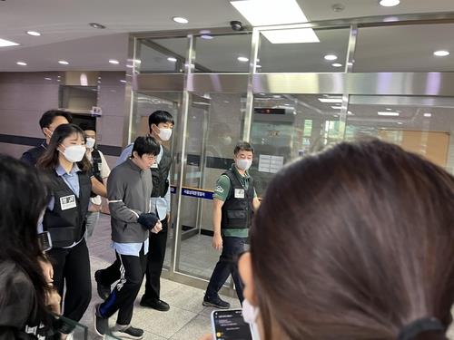 Jeon Joo-hwan (3rd from R), the 31-year-old suspect in the subway murder case, is being transferred from Seoul Namdaemun Police Station to the Seoul Central District Prosecutors Office on Sept. 21, 2022. (Yonhap)