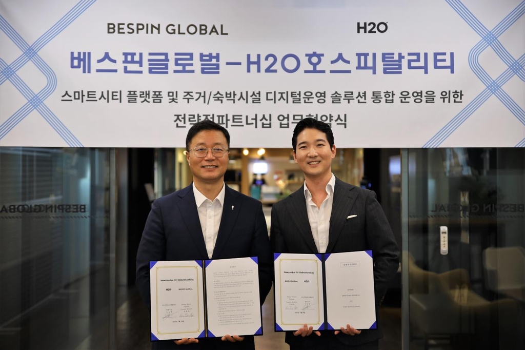 This photo, provided by H2O Hospitality Ltd. on Sept. 21, 2022, shows CEO John Lee (R) and Kim Tae-ho, country director for Bespin Global Vietnam, at a memorandum of understanding signing ceremony held in Seoul. (PHOTO NOT FOR SALE) (Yonhap)