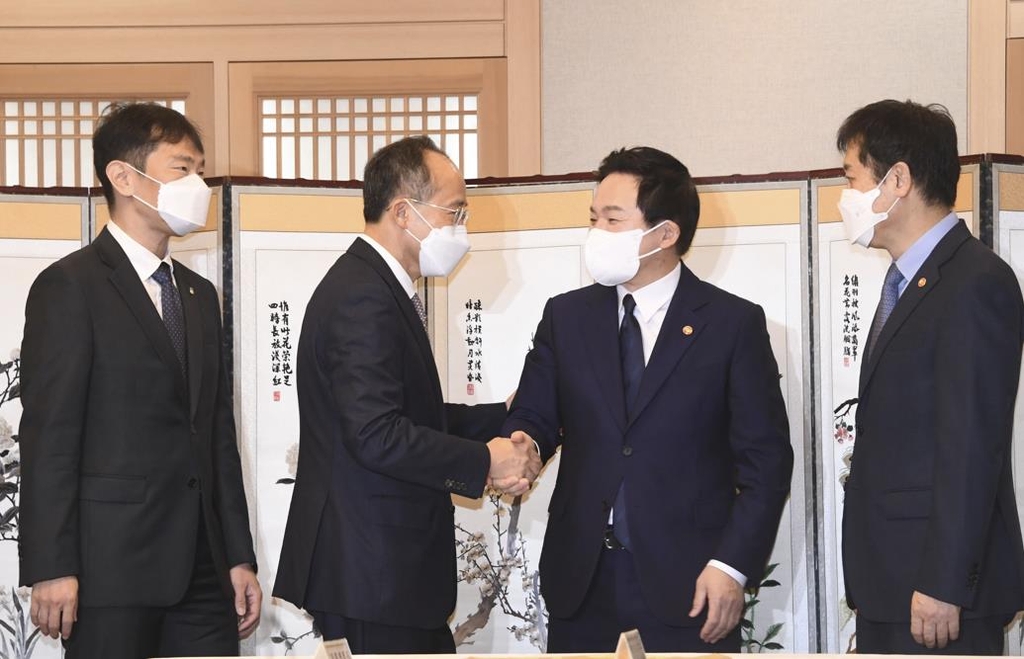 Finance Minister Choo Kyung-ho (2nd from L), shakes hands with Land Minister Won Hee-ryong (2nd from R) ahead of a ministers' meeting in Seoul on Nov. 10, 2022, in this photo provided by the Ministry of Economy and Finance. (PHOTO NOT FOR SALE) (Yonhap)