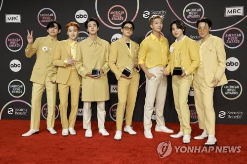 This AFP photo shows BTS posing with trophies at the 2021 American Music Awards in Los Angeles on Nov. 21, 2021. (Yonhap)