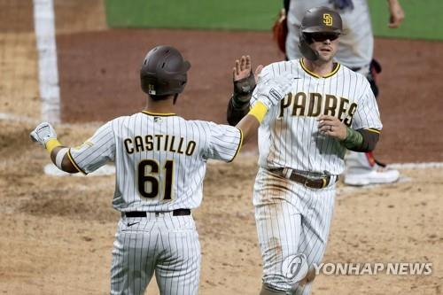 In this Getty Images file photo from May 14, 2021, Brian O'Grady of the San Diego Padres (R) is greeted by teammate Ivan Castillo after scoring on a sacrifice fly by Kim Ha-seong during the bottom of the seventh inning of a Major League Baseball regular season game at Petco Park in San Diego. (Yonhap)