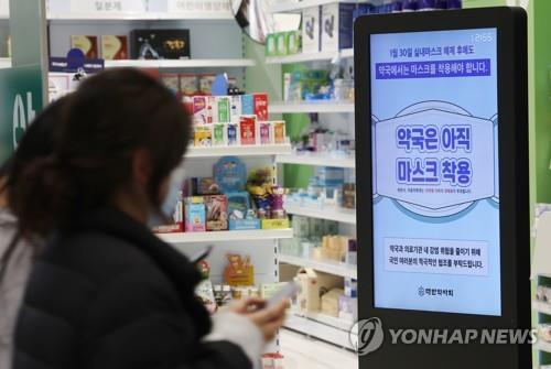 A notice in front of a pharmacy inside Incheon International Airport shows a mask-wearing mandate still in effect at pharmacies on Jan. 31, 2023. (Yonhap)