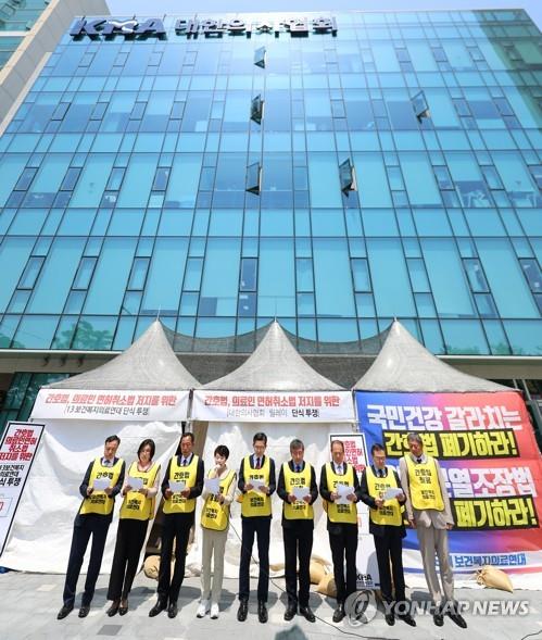 Representatives of 13 associations of doctors, nursing assistants and other health workers issue a statement in front of the Korean Medical Association in Seoul on May 16, 2023, welcoming President Yoon Suk Yeol's veto earlier in the day of the controversial nursing act unilaterally passed by the opposition. (Yonhap) 