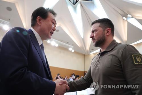 South Korean President Yoon Suk Yeol (L) shakes hands with Ukrainian President Volodymyr Zelenskyy during an expanded session of the Group of Seven summit in Hiroshima, Japan, on May 21, 2023. (Pool photo) (Yonhap)