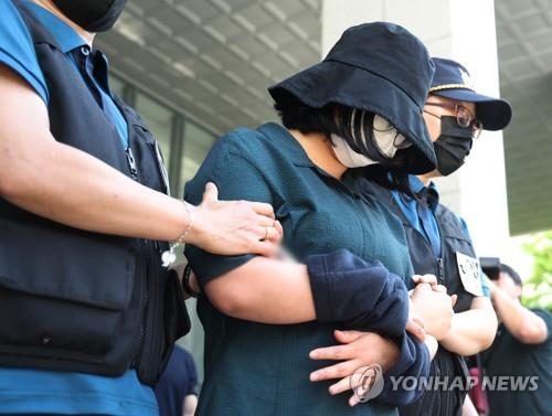 Murder suspect Jung Yoo-jung, wearing a hat and a mask, leaves a police detention center en route to the prosecution in Busan on June 2, 2023. (Yonhap)