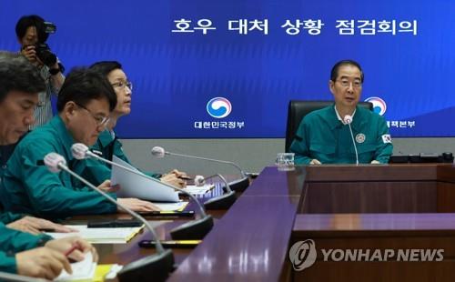 El primer ministro Han Duck-soo (derecha) preside una reunión de respuesta del gobierno en Seúl el 16 de julio de 2023, después de que las fuertes lluvias dejaran al menos 32 muertos.  (Yonhap) 