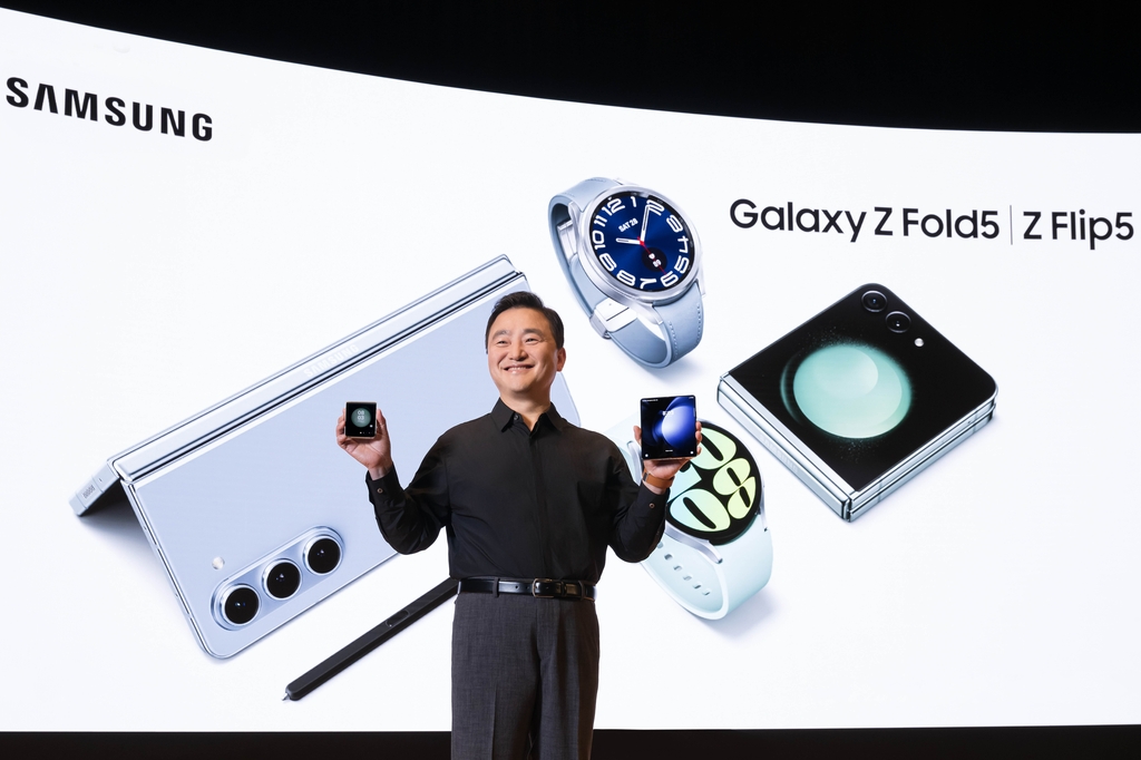Roh Tae-moon, president and head of Samsung Electronics' mobile division, holds the Galaxy Z Flip 5 and the Fold 5 during the Galaxy Unpacked in Seoul on July 26, 2023, in this photo provided by the company. (PHOTO NOT FOR SALE) (Yonhap)