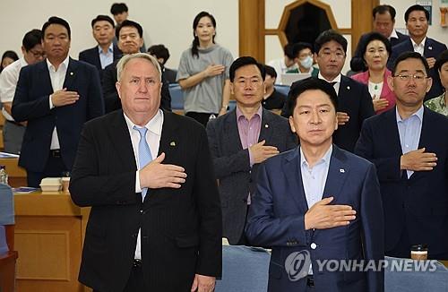 Yohan Ihn (L) salutes the national flag at the headquarters of the ruling People Power Party in Seoul on Oct. 23, 2023. (Yonhap)