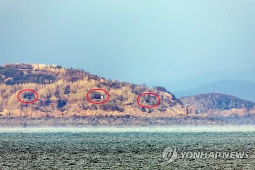 Esta foto, tomada desde una torre de observación en la isla Yeonpyeong de Corea del Sur, que limita con Corea del Norte en el Mar Occidental, muestra las entradas de las posiciones de artillería (en círculos rojos) que se abrieron en la isla Jangjae de Corea del Norte el 29 de noviembre de 2023, días después de la amenaza de restablecer inmediatamente todas las medidas militares previamente suspendidas en virtud de un acuerdo militar intercoreano de 2018 destinado a mitigar las tensiones militares.  (Yonhap)