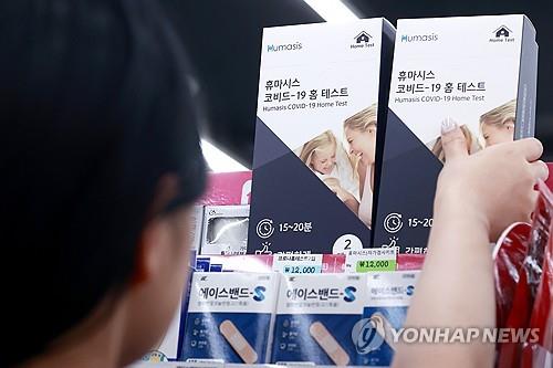 A person picks up COVID-19 self-test kits at a convenience store in Seoul on Aug. 7, 2024, amid signs of a resurgence in coronavirus cases. (Yonhap) 