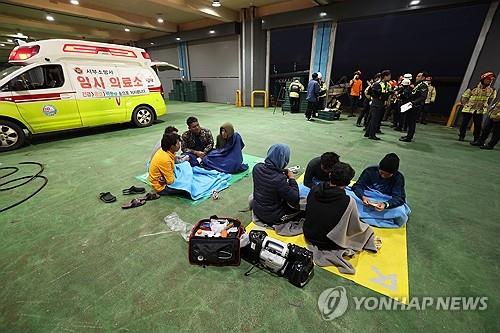 Los miembros de la tripulación rescatados de un barco pesquero que se hunde esperan a ser trasladados a un hospital en el puerto de Hallim en Jeju el 8 de noviembre de 2024. (Yonhap)