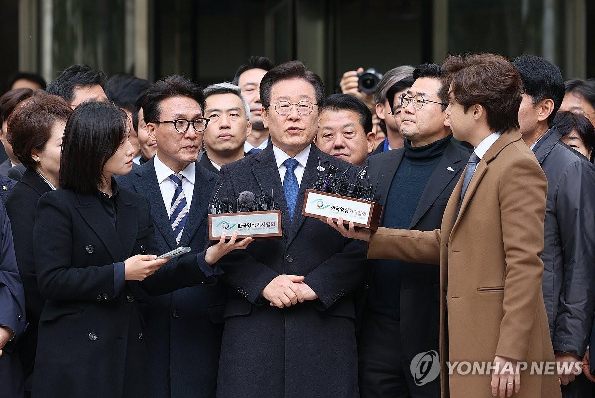 Lee Jae-myung (centro), líder del principal partido opositor, el Partido Demócrata, habla con los periodistas después de ser absuelto de soborno de cargos de perjurio en el Tribunal del Distrito Central de Seúl el 25 de noviembre de 2024. (Foto de la piscina) (Yonhap)